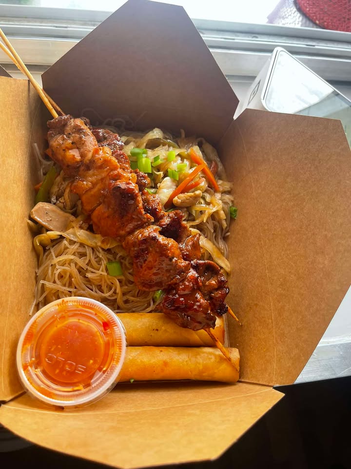 Filipino BBQ chicken skewers over pancit noodles